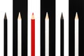 Red pencil standing out from crowd of black and white fellows on bw stripe background. business success concept of leadership