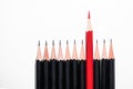 One red pencil among black pencils Royalty Free Stock Photo