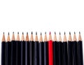 Red pencil standing out from crowd of plenty identical black fellows on white background. business success concept