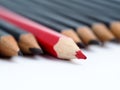 Red pencil standing out from crowd of plenty identical fellows Royalty Free Stock Photo