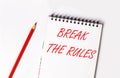 Red pencil and white notepad with the text BREAK THE RULES Royalty Free Stock Photo