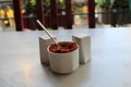 Red pepper flakes in a porcelain cup with a tiny spoon Royalty Free Stock Photo