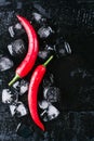 Red pepper ice on a black wood background, fresh hot food on vintage table, freeze cold cube ice, mock up top view