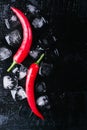 Red pepper and ice on a black wood background, fresh hot food on vintage table, freeze cold cube ice, mock up top view