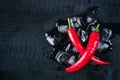 Red pepper and ice on a black wood background, fresh hot food on vintage table, freeze cold cube ice, mock up top view