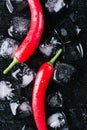 Red pepper and ice on a black wood background, fresh hot food on vintage table, freeze cold cube ice, mockup top view