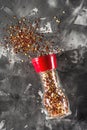 Red pepper mill with spices and salt on gray Royalty Free Stock Photo