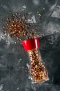 Red pepper mill with spices and salt on gray Royalty Free Stock Photo