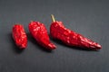 Red pepper. Three red dry peppers stacked on a black slate stone. Hot chili peppers Royalty Free Stock Photo