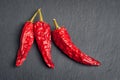 Red pepper. Top view of three red dry peppers stacked on black shale stone. Hot chili peppers Royalty Free Stock Photo