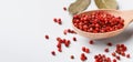 Red peppercorn balls in wooden spoon on white background Royalty Free Stock Photo