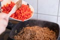 Red peppers being added to minced meat Royalty Free Stock Photo