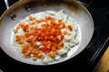 Red peppers and onions sauteing in fry pan