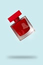 Red perfume bottle flying on a blue background. The concept of a favorite fragrance Royalty Free Stock Photo