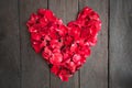 Red petal roses shaped like a heart on wood background,