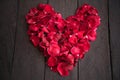 Red petal roses shaped like a heart on wood background,