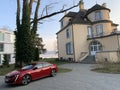 Red peugeot 508. car parked in front of luxury housing.