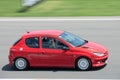 Red Peugeot 206 racing on the racing circuit