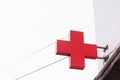 A red pharm medical cross sign on the street against a clear white sky with wires on it