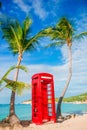 Beautiful landscape with a classic phone booth on the white sandy beach in Antigua Royalty Free Stock Photo