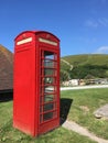 Red phone booth in landscape in Dorset, England UK