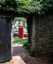 Red phone, open door and a stone wall