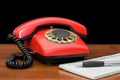 Red phone on a wooden table Royalty Free Stock Photo