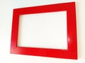 Red photo frame on a white background. The frame is photographed at an angle. Shiny lacquered wood surface. Light shadows. Copy Royalty Free Stock Photo