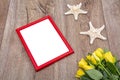 Red photo frame and yellow roses on a table Royalty Free Stock Photo