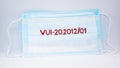 Red phrase VUI-202012 01 on a medical mask on a white background. The concept of medicine and coronavirus.