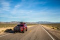 Red pickup camping truck travelling through the Nevada desert along the Extraterrestrial Highway