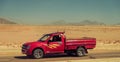 Red pickup truck moving fast through desert road Royalty Free Stock Photo