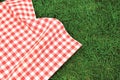 000Red picnic  towel on green grass top view, checked cloth flat lay. Food advertisement display Royalty Free Stock Photo
