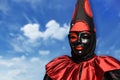Red Pierrot carnival mask, with sky background and clouds, Venice, Italy