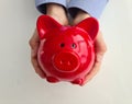 Red piggy bank in children hands and children allowances Royalty Free Stock Photo