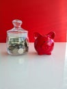 Red piggy bank and glass jar for collecting coins