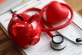 Red piggy bank stethoscope and toy heart lying at health insurance claim form Royalty Free Stock Photo