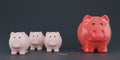 Red piggy bank with three small piggy banks