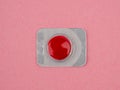 Red pill on a pink background. Sealed red pill. . Royalty Free Stock Photo
