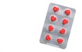 Red pills in the shape of a heart in a blister. Pill packaging on a white background. Creative concept. Copy space. 3D render