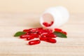 Red pills spilled around a pill bottle. Medicines and prescription pills flat lay background. Red medical capsules Royalty Free Stock Photo