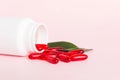 Red pills spilled around a pill bottle. Medicines and prescription pills flat lay background. Red medical capsules Royalty Free Stock Photo