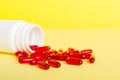 Red pills spilled around a pill bottle. Medicines and prescription pills flat lay background. Red medical capsules Royalty Free Stock Photo