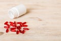 Red pills spilled around a pill bottle. Medicines and prescription pills flat lay background. Red medical capsules Royalty Free Stock Photo