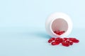 Red pills spilled around a pill bottle. Medicines and prescription pills flat lay background. Red medical capsules Royalty Free Stock Photo