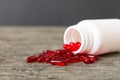 Red pills spilled around a pill bottle. Medicines and prescription pills flat lay background. Red medical capsules Royalty Free Stock Photo