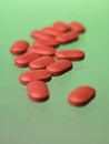 Red pills toward green background Royalty Free Stock Photo