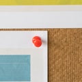 Red pin attachment paper on cork board in office. Royalty Free Stock Photo