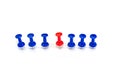 Red pin in the middle of blue pins on a white background. Stand out, think differently. individuality and leadership concept.