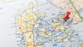 A red board pin stuck in Copenhagen on a map of Denmark